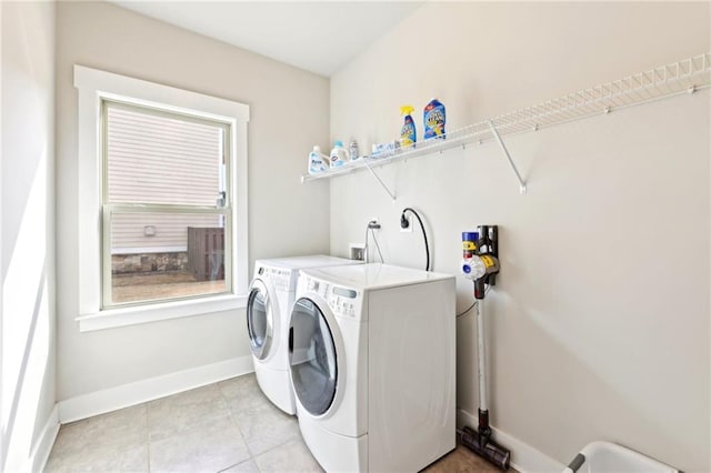 laundry room featuring laundry area, light tile patterned floors, baseboards, and washing machine and clothes dryer