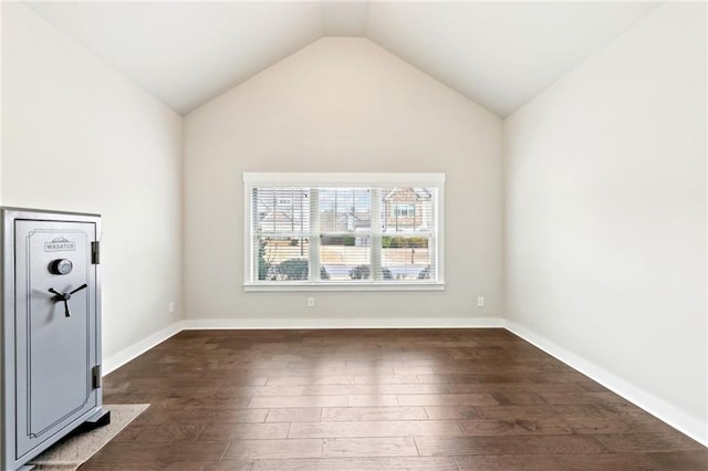 unfurnished room with dark wood-style floors, baseboards, and lofted ceiling