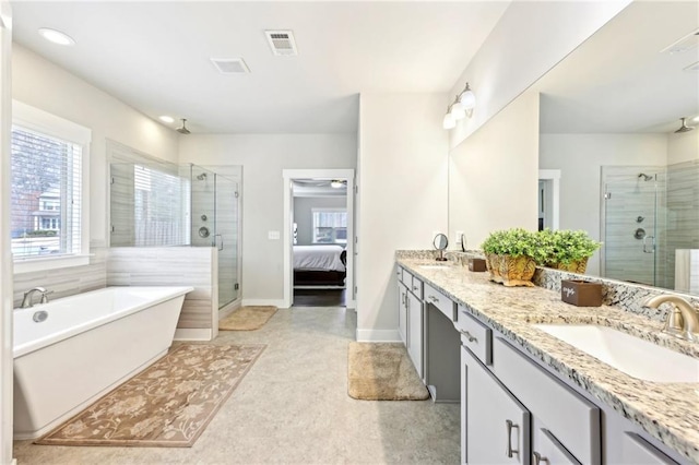 bathroom featuring visible vents, a stall shower, a freestanding bath, and a sink