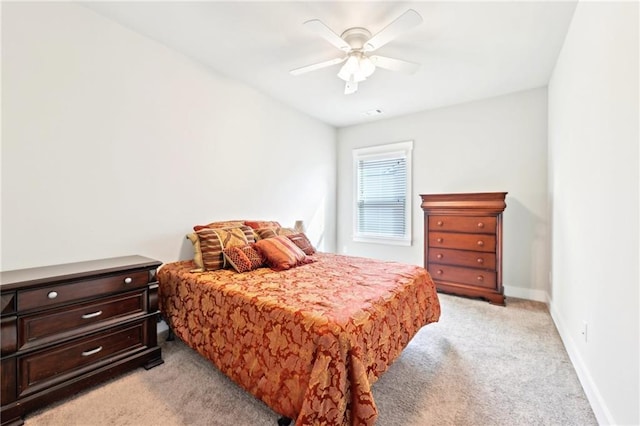 bedroom featuring light carpet, a ceiling fan, and baseboards