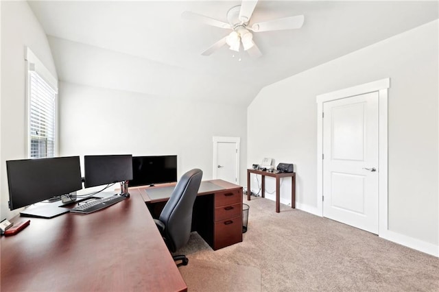 office area featuring lofted ceiling, light colored carpet, baseboards, and ceiling fan