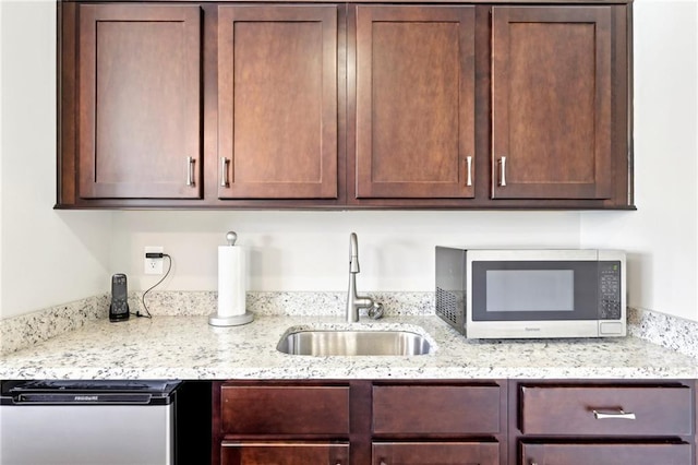 kitchen featuring dark brown cabinetry, appliances with stainless steel finishes, and a sink