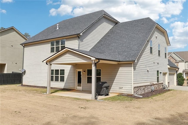 back of house featuring fence, a shingled roof, driveway, and a patio area