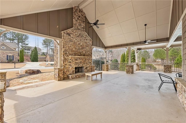 view of patio featuring an outdoor stone fireplace and a ceiling fan