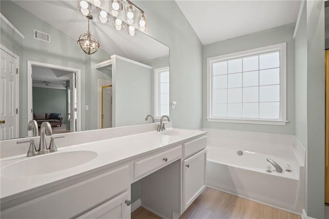 405 Sable Ct, Milton, GA 30004 - ensuite bathroom featuring double vanity, a bath, a stall shower, wood finished floors, and a chandelier