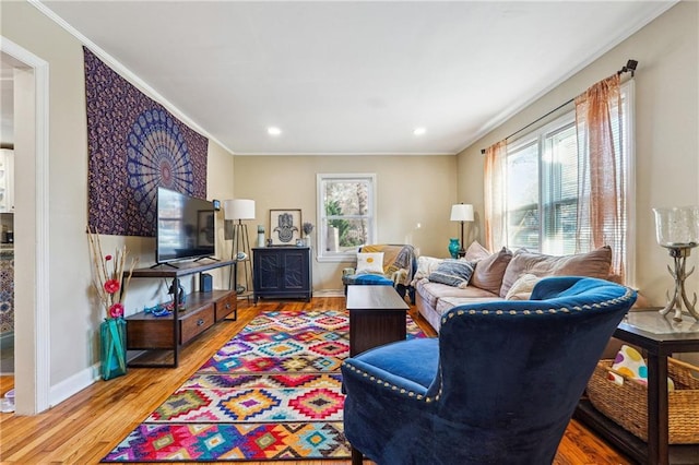 living area featuring light wood finished floors, recessed lighting, baseboards, and ornamental molding