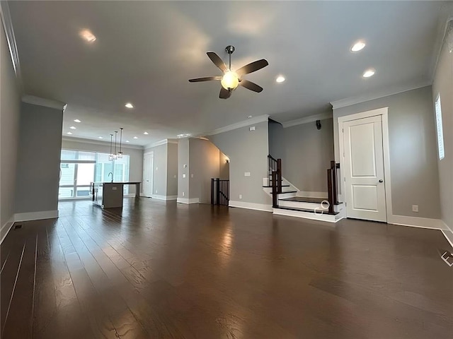 unfurnished living room featuring ceiling fan, crown molding, dark wood-type flooring, and sink