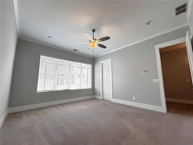 spare room featuring crown molding, ceiling fan, and light colored carpet