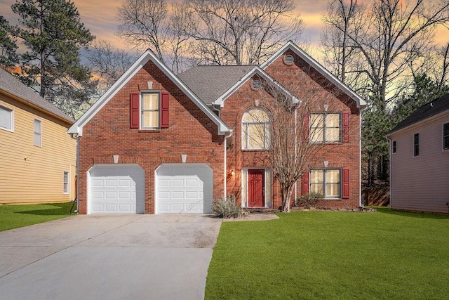 view of front of home featuring a garage, a yard, concrete driveway, and brick siding