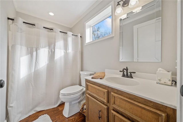 bathroom featuring toilet, ornamental molding, wood-type flooring, and vanity