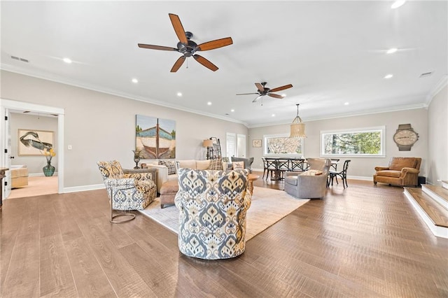 living room featuring ornamental molding, ceiling fan, and light hardwood / wood-style flooring