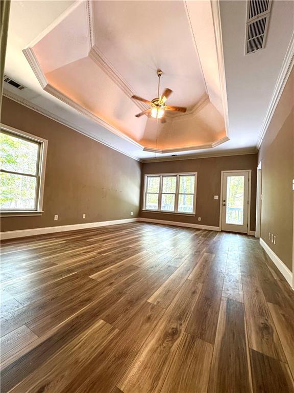 225 Austin Oaks Dr SE, Ellenwood, GA 30294 - unfurnished room featuring ornamental molding, a ceiling fan, dark wood-type flooring, visible vents, and a tray ceiling