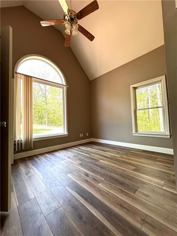 225 Austin Oaks Dr SE, Ellenwood, GA 30294 - unfurnished room with hardwood / wood-style floors, baseboards, vaulted ceiling, and ceiling fan
