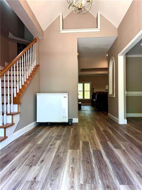 225 Austin Oaks Dr SE, Ellenwood, GA 30294 - interior space with baseboards, an inviting chandelier, stairway, high vaulted ceiling, and wood finished floors