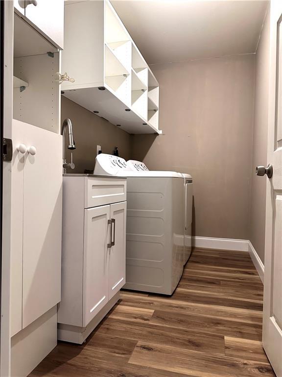 225 Austin Oaks Dr SE, Ellenwood, GA 30294 - clothes washing area featuring independent washer and dryer, baseboards, dark wood-style floors, and cabinet space