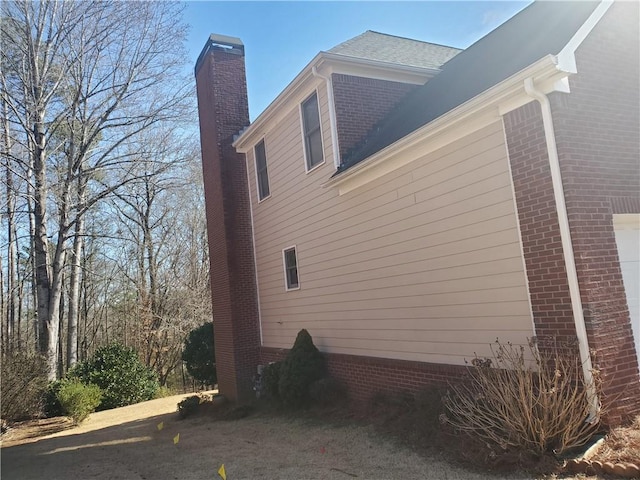 4217 Mill Grove Ln SW, Smyrna, GA 30082 - view of home's exterior featuring a chimney, brick siding, and an attached garage