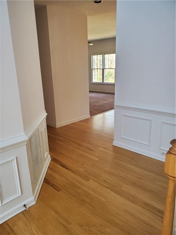 4217 Mill Grove Ln SW, Smyrna, GA 30082 - hall with a wainscoted wall, light wood-style floors, and a decorative wall