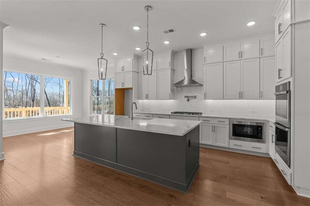 2023 Fern Mountain Ln, Marietta, GA 30064 - kitchen with stainless steel appliances, light countertops, visible vents, a sink, and wall chimney exhaust hood