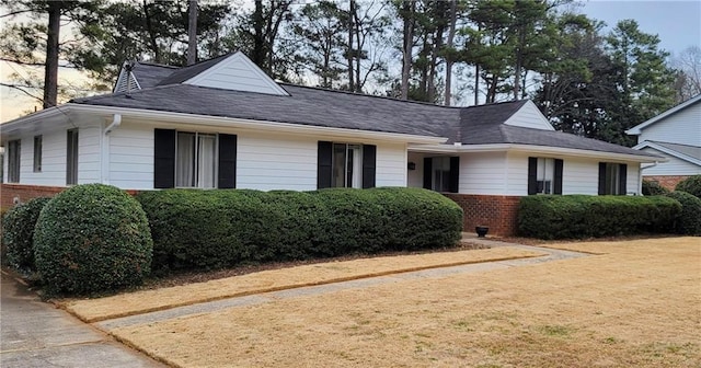 view of front facade with brick siding and a front yard