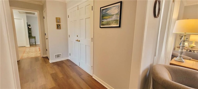 hallway with dark wood-type flooring, baseboards, and visible vents