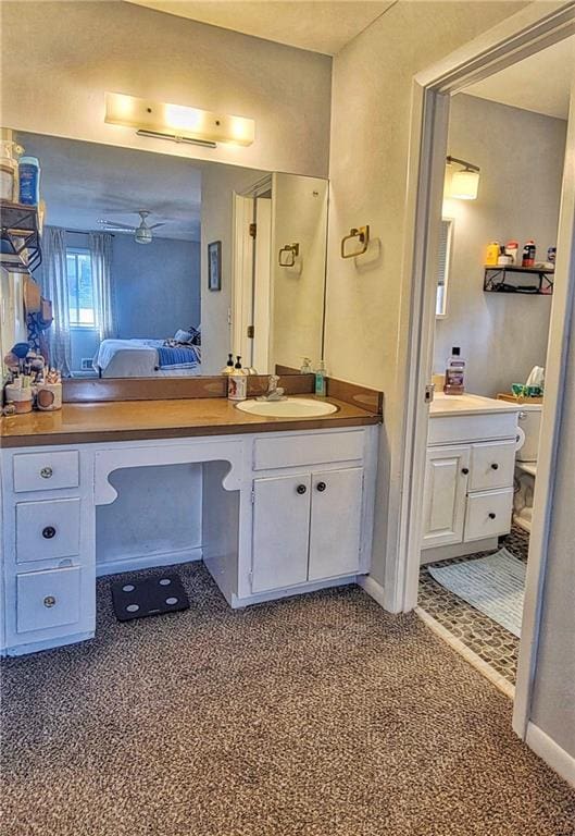 ensuite bathroom with baseboards, ensuite bath, and vanity