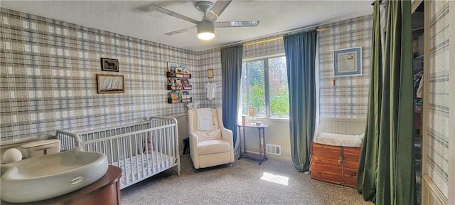 carpeted bedroom with visible vents, a nursery area, wallpapered walls, and baseboards