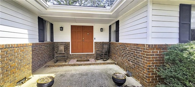 view of exterior entry featuring brick siding