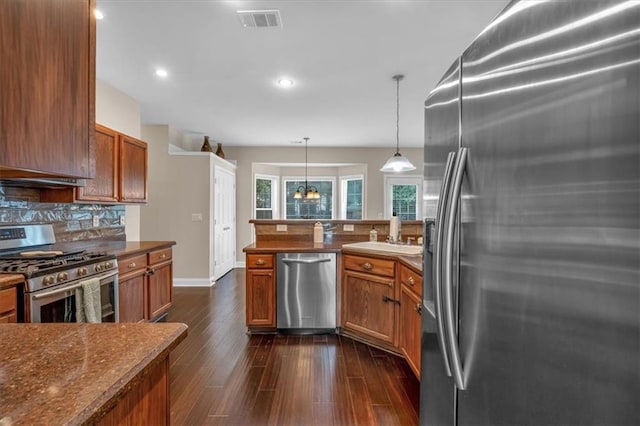 812 Roget Way, Lawrenceville, GA 30045 - kitchen with stainless steel appliances, brown cabinetry, backsplash, a sink, and dark wood-style floors