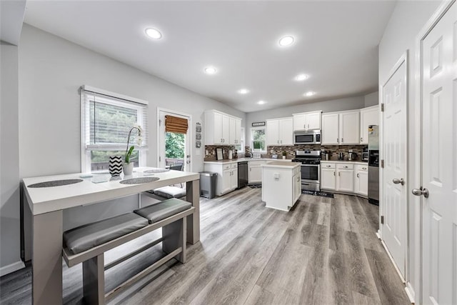 402 Homestead Dr, Dallas, GA 30157 - kitchen with appliances with stainless steel finishes, backsplash, white cabinets, light wood finished floors, and recessed lighting