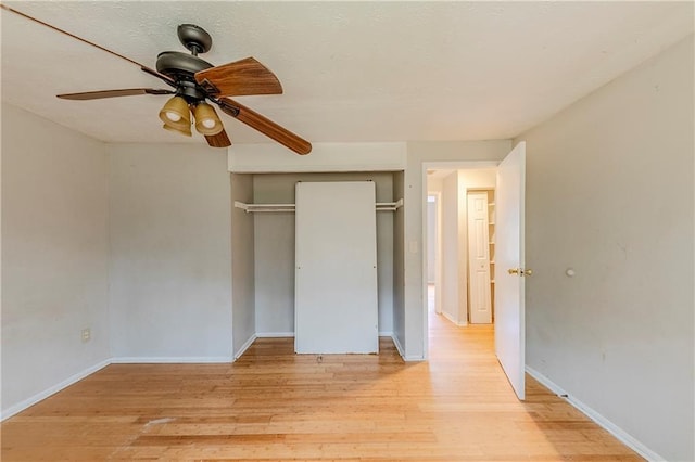 unfurnished bedroom with ceiling fan, light wood-type flooring, and a closet