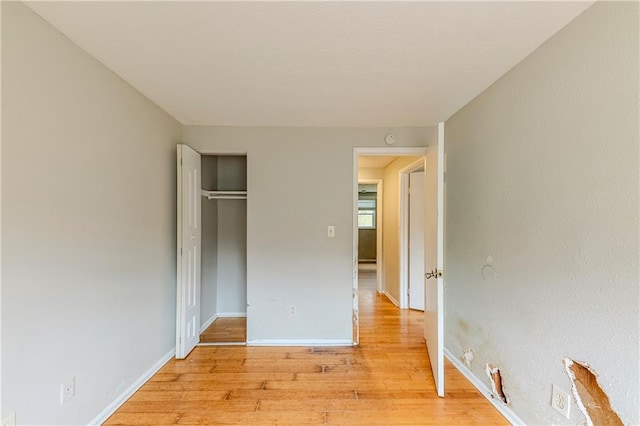 unfurnished bedroom featuring light hardwood / wood-style floors and a closet