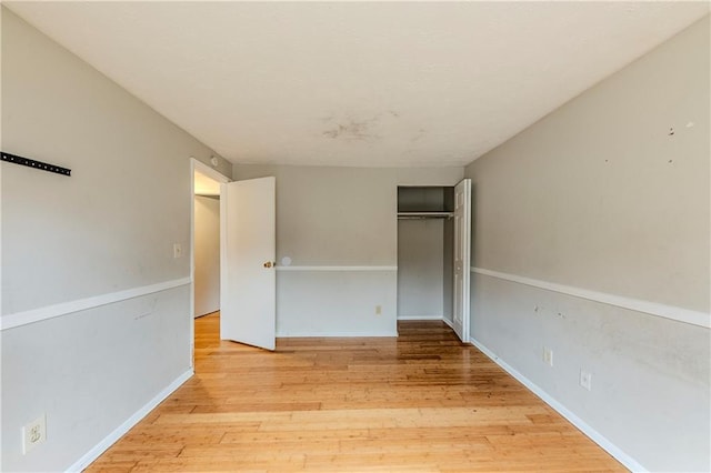 unfurnished bedroom with a closet and light hardwood / wood-style flooring