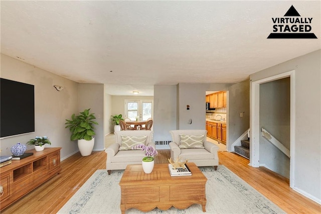 living room with sink and light hardwood / wood-style flooring