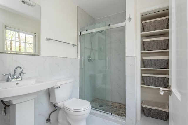 6795 Brandon Mill Rd, Atlanta, GA 30328 - full bathroom featuring marble look tiles, a marble finish shower, toilet, tile walls, and wainscoting