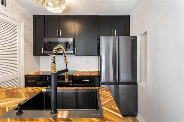 kitchen featuring appliances with stainless steel finishes and a notable chandelier