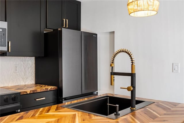 kitchen featuring stainless steel fridge, wooden counters, decorative backsplash, parquet floors, and sink