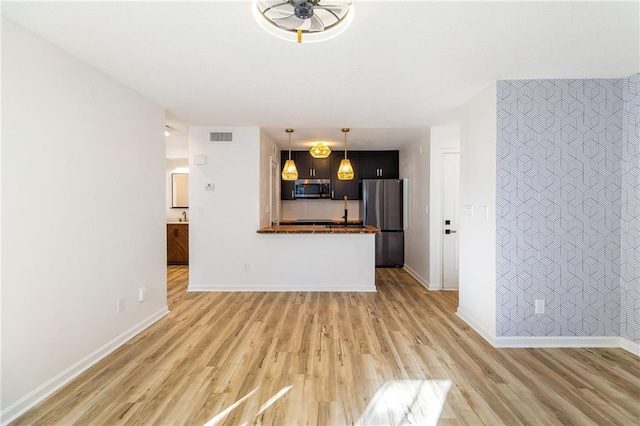 unfurnished living room with ceiling fan and light wood-type flooring