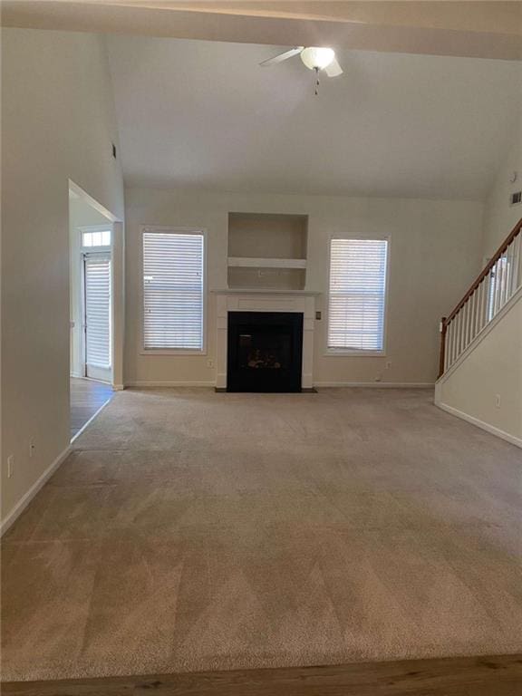 unfurnished living room featuring ceiling fan, light carpet, and vaulted ceiling