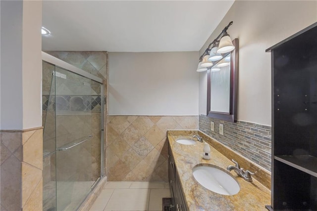 bathroom featuring a shower with door, vanity, tile walls, and tile patterned floors