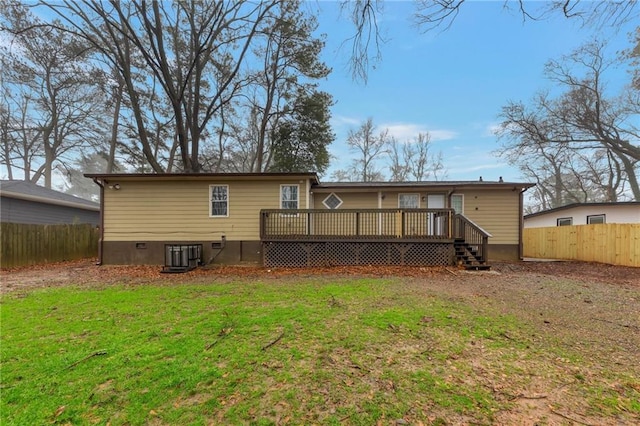 rear view of house with central AC unit, a lawn, and a deck