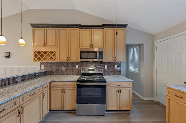 kitchen featuring lofted ceiling, appliances with stainless steel finishes, and hanging light fixtures