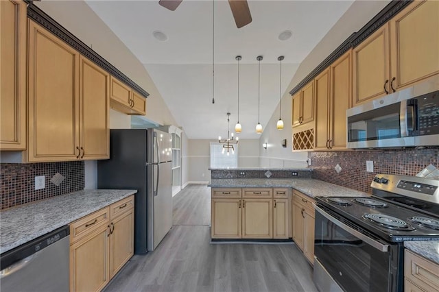 kitchen featuring stainless steel appliances, vaulted ceiling, pendant lighting, and light stone counters