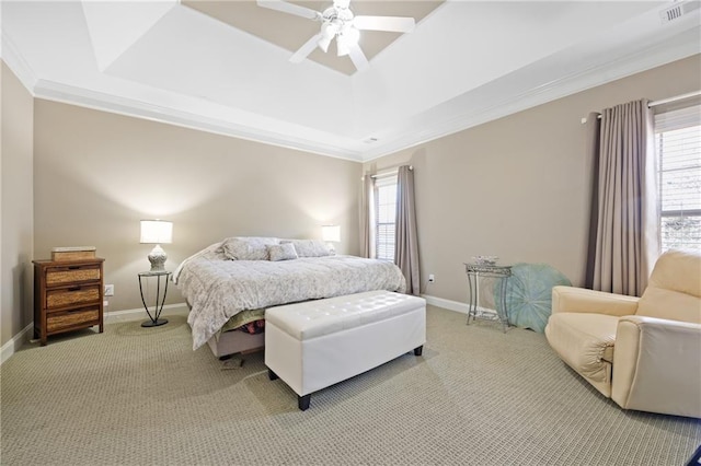 bedroom featuring a tray ceiling, visible vents, crown molding, and baseboards