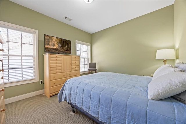 bedroom featuring baseboards, visible vents, and light colored carpet