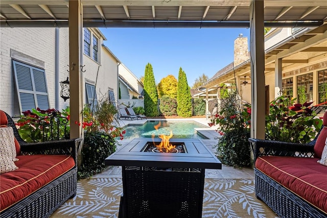 view of patio with an outdoor living space with a fire pit