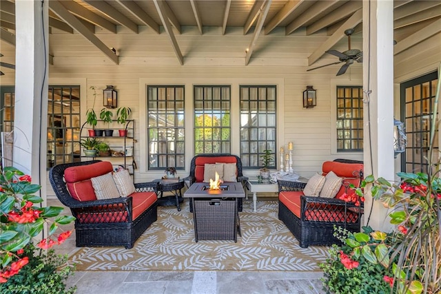 view of patio / terrace featuring ceiling fan and an outdoor living space with a fire pit