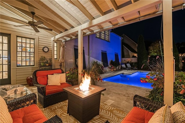 view of pool featuring pool water feature, a patio, and an outdoor living space with a fire pit