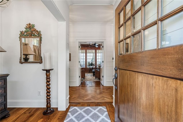 foyer entrance with ceiling fan and dark parquet flooring