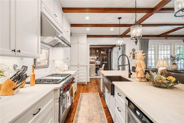 kitchen featuring dishwashing machine, sink, white cabinets, decorative light fixtures, and range with two ovens