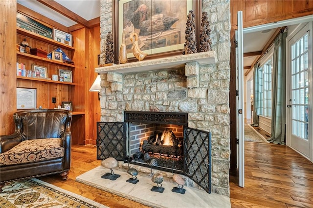 sitting room featuring hardwood / wood-style flooring, plenty of natural light, a fireplace, and built in shelves